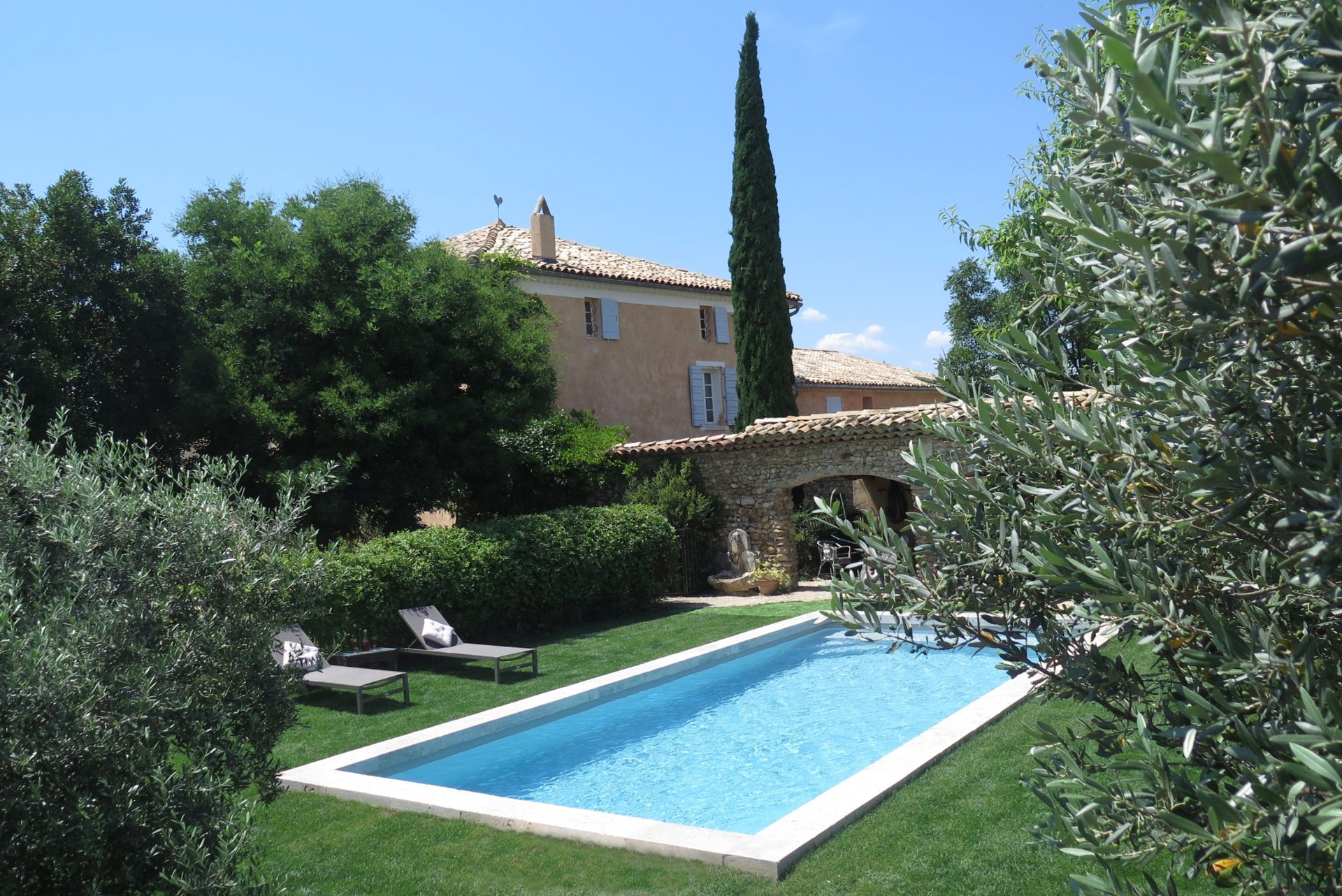 La piscine, le cyprès et la façade de la bastide