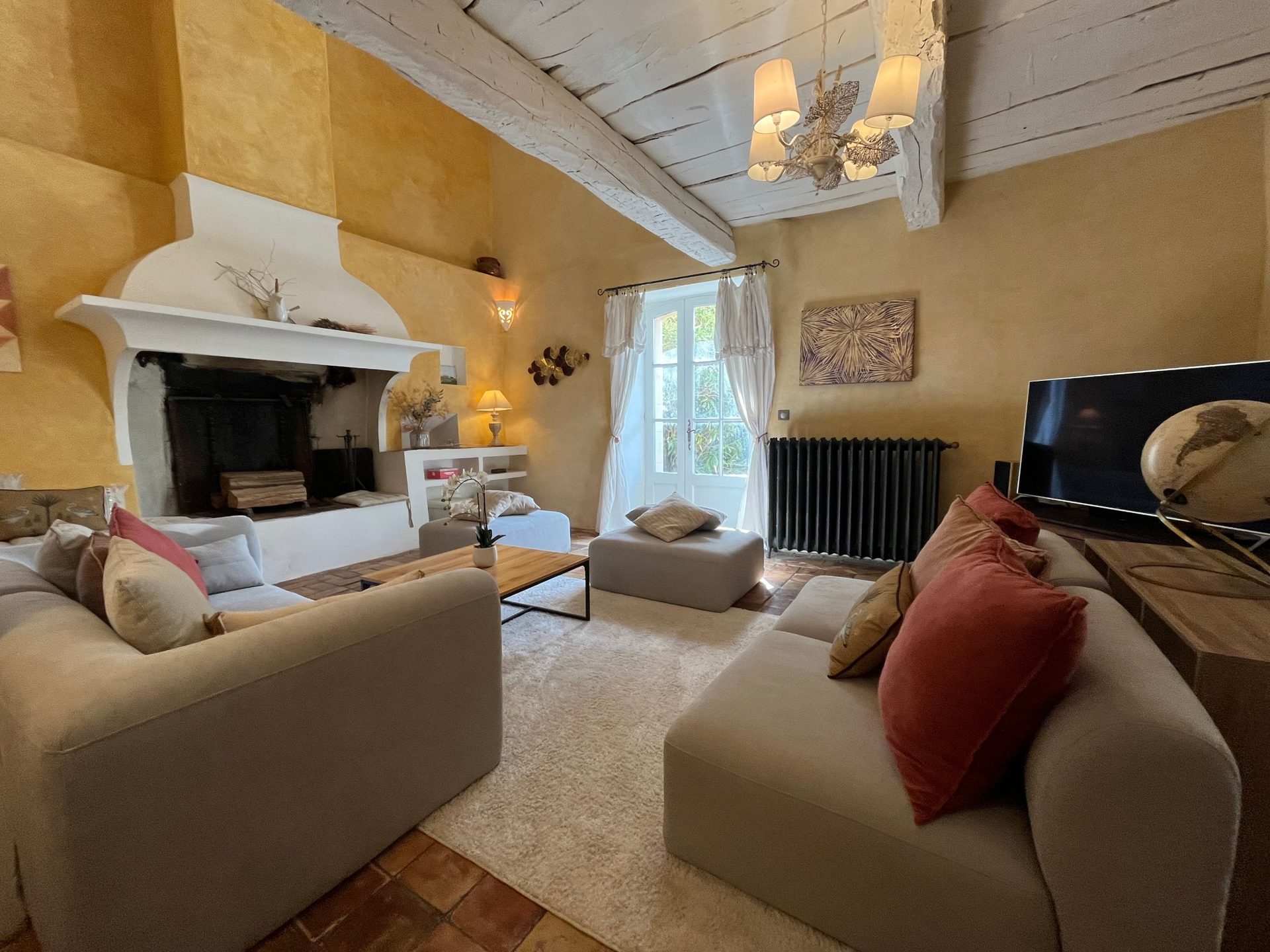 Le salon de la bastide, cheminée et poutres anciennes
